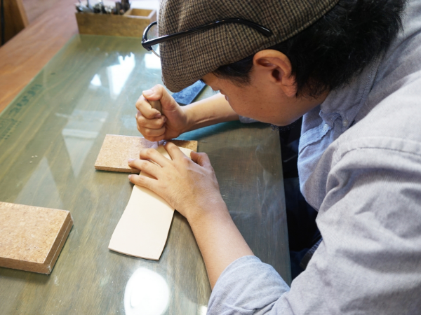 帽子を被った男性の生徒が作業している様子の写真