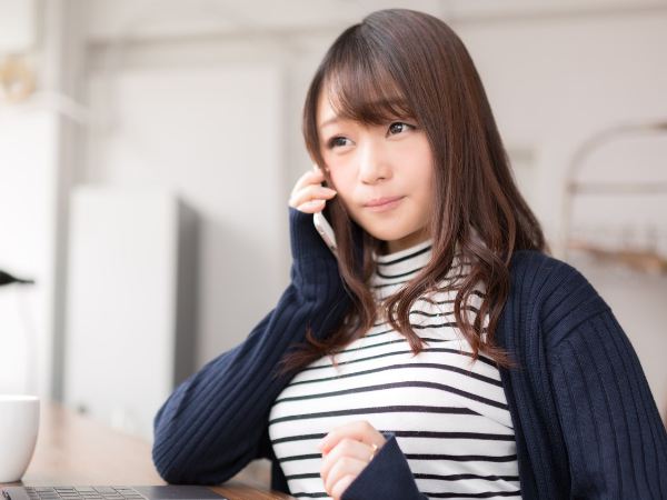 女性の生徒がスマホで電話をしている様子の写真